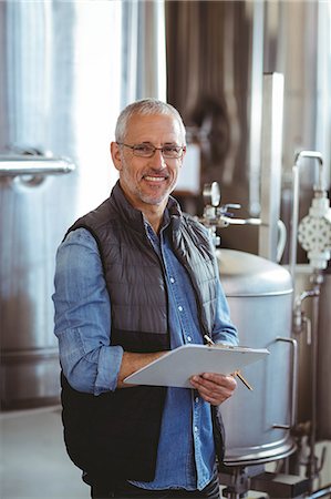 Happy brewer checking his list at the local brewery Foto de stock - Sin royalties Premium, Código: 6109-08489278