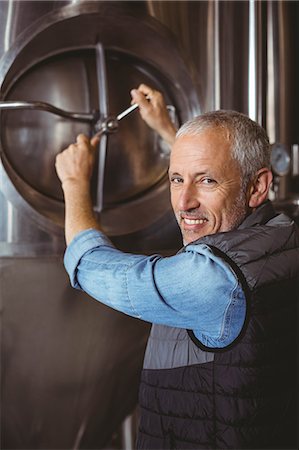 Happy brewer checking large vats at the local brewery Stock Photo - Premium Royalty-Free, Code: 6109-08489297