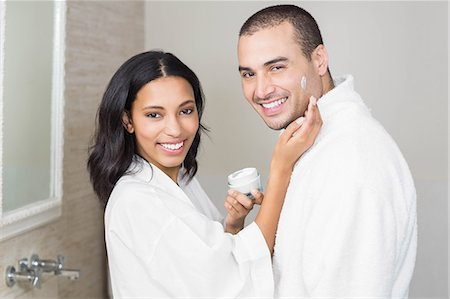 simsearch:6109-08435535,k - Smiling brunette putting on her husband cream in bathroom Stock Photo - Premium Royalty-Free, Code: 6109-08489216