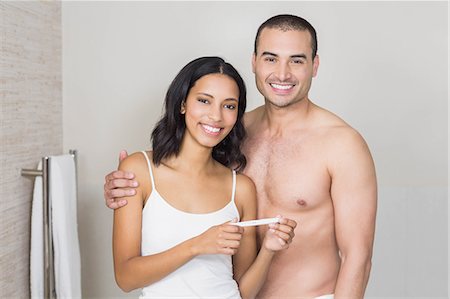 simsearch:6109-08435552,k - Smiling couple looking at pregnancy test in bathroom Fotografie stock - Premium Royalty-Free, Codice: 6109-08489223
