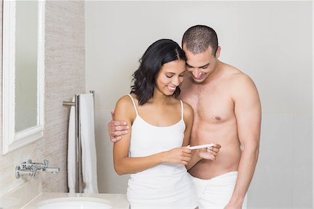 simsearch:6109-08435552,k - Smiling couple looking at pregnancy test in bathroom Fotografie stock - Premium Royalty-Free, Codice: 6109-08489222