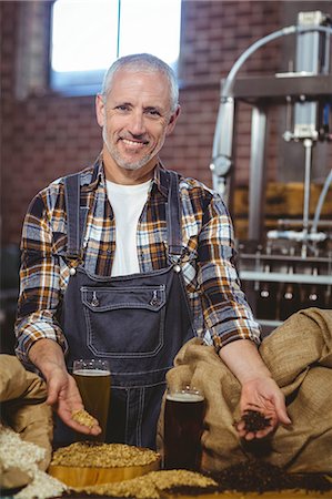 Happy brewer showing grain and produce at the local brewery Stock Photo - Premium Royalty-Free, Code: 6109-08489362