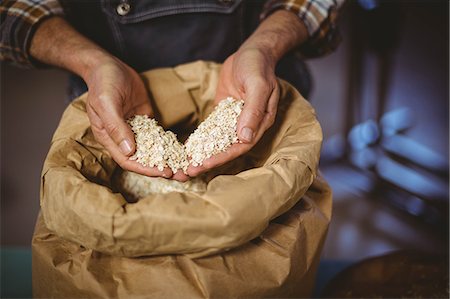 simsearch:6109-08489527,k - Happy brewer showing grain and produce at the local brewery Foto de stock - Sin royalties Premium, Código: 6109-08489367