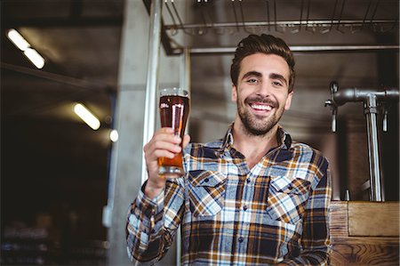 Happy brewer showing pint of beer at the local brewery Stock Photo - Premium Royalty-Free, Code: 6109-08489443