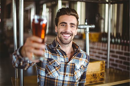 simsearch:6109-08489440,k - Happy brewer showing his pint at the local brewery Stock Photo - Premium Royalty-Free, Code: 6109-08489446