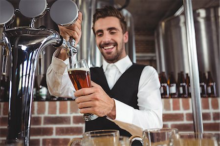 simsearch:6109-08489706,k - Handsome barman pouring beer in a pub Foto de stock - Royalty Free Premium, Número: 6109-08489497