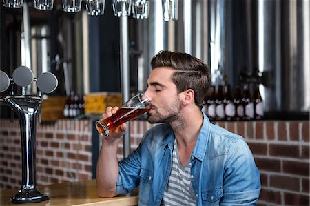 Handsome man drinking a pint of beer in a pub Foto de stock - Sin royalties Premium, Código: 6109-08489498