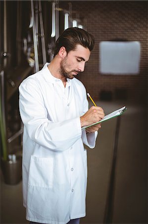 simsearch:6109-08489534,k - Focused brewer working in the plant at the local brewery Photographie de stock - Premium Libres de Droits, Code: 6109-08489427