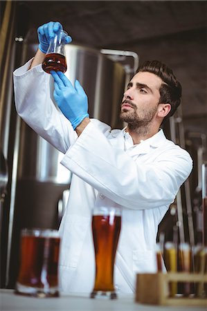 Focused brewer checking beaker of beer at the local brewery Foto de stock - Sin royalties Premium, Código: 6109-08489435