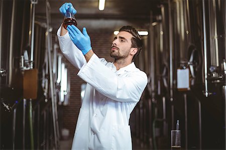 Focused brewer checking beaker of beer at the local brewery Foto de stock - Sin royalties Premium, Código: 6109-08489436