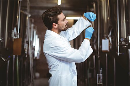 simsearch:6109-08489534,k - Focused brewer checking beer at the local brewery Photographie de stock - Premium Libres de Droits, Code: 6109-08489438