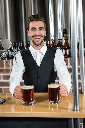 simsearch:6109-08394900,k - Handsome barman giving two beers in a pub Foto de stock - Royalty Free Premium, Número: 6109-08489560