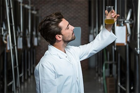 simsearch:6109-08489628,k - Focused brewer testing his beer at the microbrewery Foto de stock - Royalty Free Premium, Número: 6109-08489577