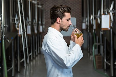 simsearch:6109-08489655,k - Focused brewer testing his beer in the brewery factory Foto de stock - Royalty Free Premium, Número: 6109-08489575