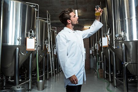 simsearch:6109-08489628,k - Focused brewer testing his beer at the microbrewery Foto de stock - Royalty Free Premium, Número: 6109-08489578