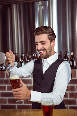 simsearch:6109-08489706,k - Handsome barman pouring a pint of beer in a pub Foto de stock - Royalty Free Premium, Número: 6109-08489581
