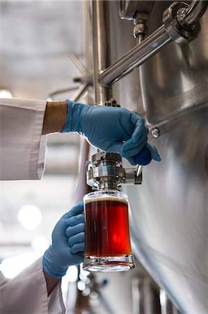 simsearch:6109-08489622,k - Focused brewer working in the plant at the local brewery Photographie de stock - Premium Libres de Droits, Code: 6109-08489595