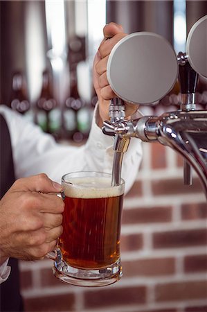 simsearch:832-03640687,k - Barman pulling a pint of beer behind the bar Stock Photo - Premium Royalty-Free, Code: 6109-08489599