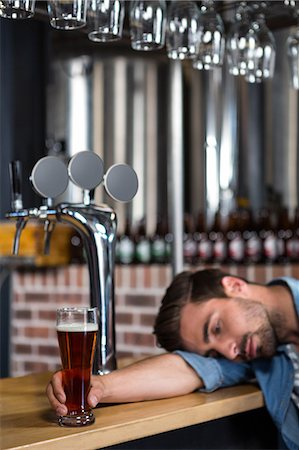 Tired man leaning on counter in a pub Stock Photo - Premium Royalty-Free, Code: 6109-08489502