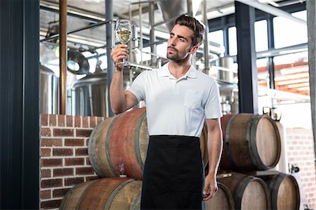 simsearch:6109-08489564,k - Handsome man holding a glass of wine in a brewery Photographie de stock - Premium Libres de Droits, Code: 6109-08489523