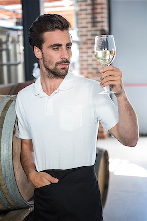 Handsome man holding a glass of wine in a brewery Foto de stock - Sin royalties Premium, Código: 6109-08489525