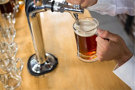 simsearch:832-03640687,k - Barman pulling a pint of beer behind the bar Stock Photo - Premium Royalty-Free, Code: 6109-08489656