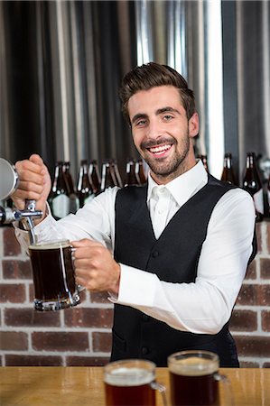 simsearch:6109-08489706,k - Handsome barman pouring a beer in a pub Foto de stock - Royalty Free Premium, Número: 6109-08489659