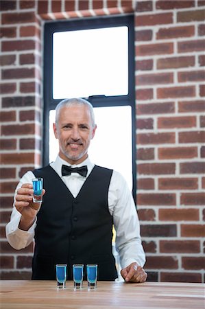 Barman giving blue shots in a pub Foto de stock - Sin royalties Premium, Código: 6109-08489663