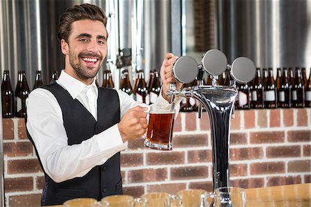 simsearch:6109-08489715,k - Handsome barman pouring a pint of beer in a pub Stock Photo - Premium Royalty-Free, Code: 6109-08489691