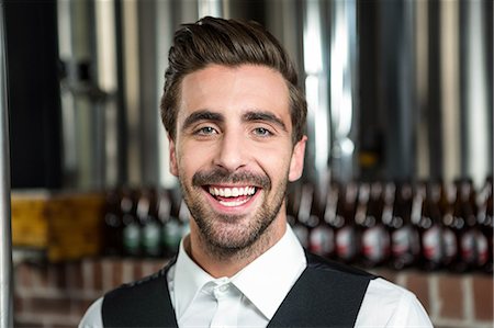 simsearch:6109-08394900,k - Handsome barman smiling at camera in a pub Foto de stock - Royalty Free Premium, Número: 6109-08489692