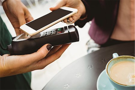 Woman paying with mobile phone in cafe Photographie de stock - Premium Libres de Droits, Code: 6109-08489751