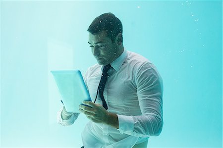 desplazar texto - Businessman using tablet pc underwater in swimming pool Foto de stock - Sin royalties Premium, Código: 6109-08489757