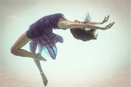 Brunette in evening gown swimming in pool underwater Foto de stock - Sin royalties Premium, Código: 6109-08489781