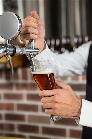 simsearch:832-03640687,k - Barman pulling a pint of beer behind the bar Stock Photo - Premium Royalty-Free, Code: 6109-08489717