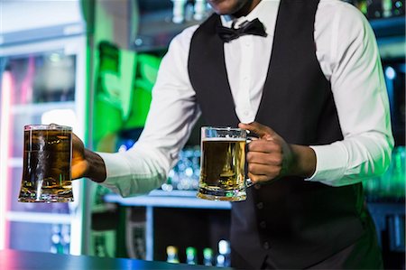 simsearch:6109-08801961,k - Bartender serving two glasses of beer at bar counter in bar Stock Photo - Premium Royalty-Free, Code: 6109-08489733