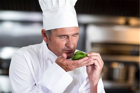 simsearch:6109-08489845,k - Chef smelling fresh basil in a commercial kitchen Stock Photo - Premium Royalty-Free, Code: 6109-08489843