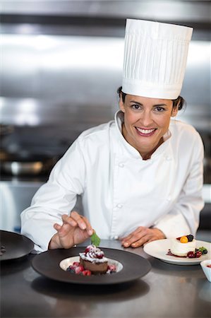 female pastry chef - Chef putting finishing touch on dessert in a commercial kitchen Foto de stock - Sin royalties Premium, Código: 6109-08489807