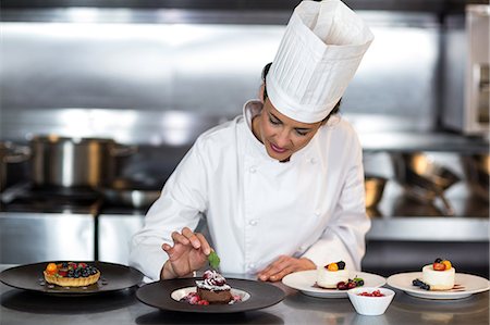 female pastry chef - Chef putting finishing touch on dessert in a commercial kitchen Foto de stock - Sin royalties Premium, Código: 6109-08489805