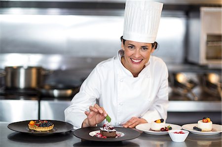 simsearch:6109-08489858,k - Chef putting finishing touch on dessert in a commercial kitchen Stock Photo - Premium Royalty-Free, Code: 6109-08489806