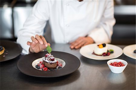 simsearch:6109-08489855,k - Chef putting finishing touch on dessert in a commercial kitchen Stock Photo - Premium Royalty-Free, Code: 6109-08489808