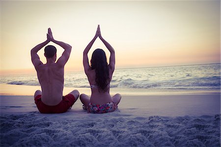 simsearch:6109-08489781,k - Happy couple doing yoga beside the water at the beach Stock Photo - Premium Royalty-Free, Code: 6109-08434593