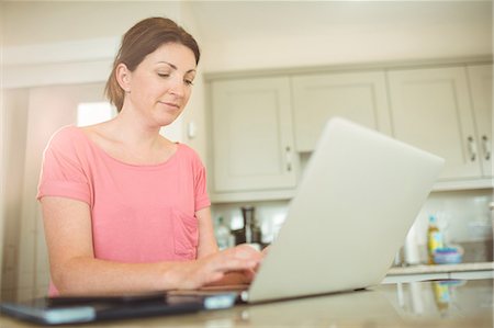 Woman using her laptop in kitchen Stock Photo - Premium Royalty-Free, Code: 6109-08434673