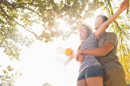 simsearch:6109-07497260,k - Cute couple hugging and holding balloons in the park on a sunny day Photographie de stock - Premium Libres de Droits, Code: 6109-08434604