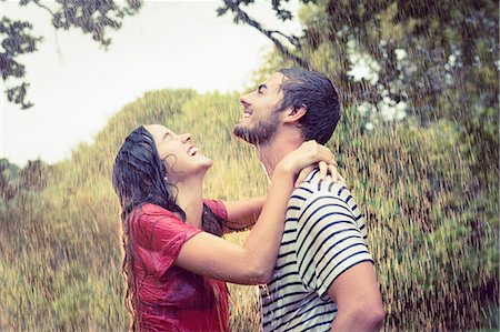 simsearch:6109-08435738,k - Handsome man carrying his girlfriend under the rain in the park Photographie de stock - Premium Libres de Droits, Code: 6109-08434618