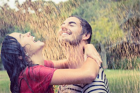 Cute couple hugging under the rain in the park Stock Photo - Premium Royalty-Free, Code: 6109-08434619