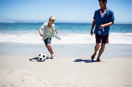 father and son playing football at beach - Father and son playing soccer on the beach Stock Photo - Premium Royalty-Free, Code: 6109-08434781