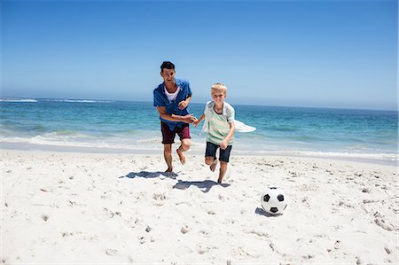 Father and son playing soccer on the beach Stock Photo - Premium Royalty-Free, Code: 6109-08434782