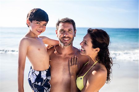 family on beach swimsuits - Cute couple carrying their son on the beach Photographie de stock - Premium Libres de Droits, Code: 6109-08434848