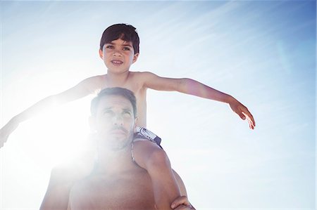 Father giving piggy back to his son on the beach Photographie de stock - Premium Libres de Droits, Code: 6109-08434855