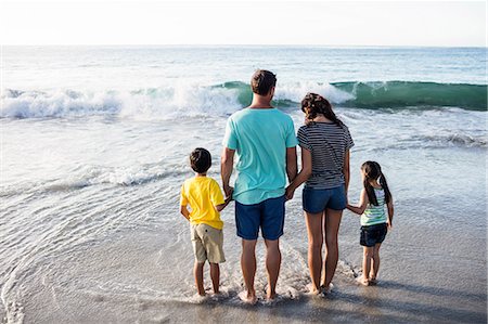 simsearch:6109-08434823,k - Cute family standing in the water on the beach Stock Photo - Premium Royalty-Free, Code: 6109-08434866